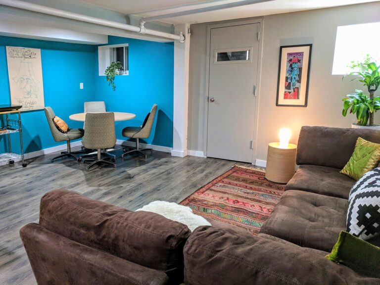 Comfortable living room with a brown sectional sofa, colorful rug, and blue accent wall, creating a warm and inviting space.